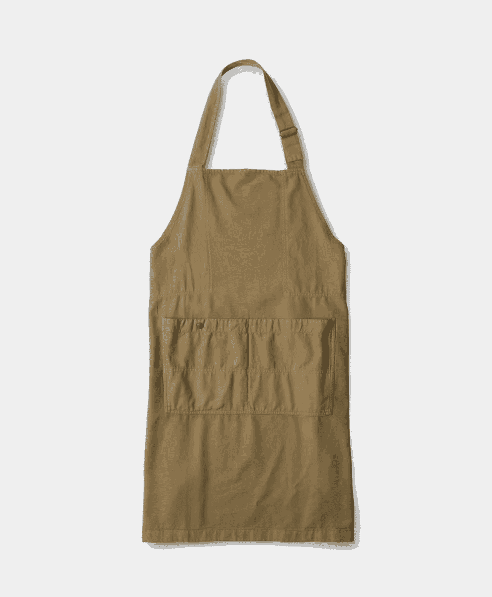 Margaret Howell Apron hanging against a neutral background.