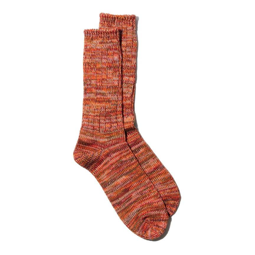 Marled orange and red hand-knit socks with a textured, sunset-inspired appearance.