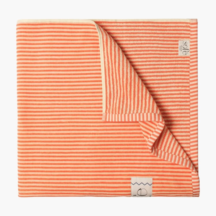 A folded orange and cream striped towel with a soft, textured finish.