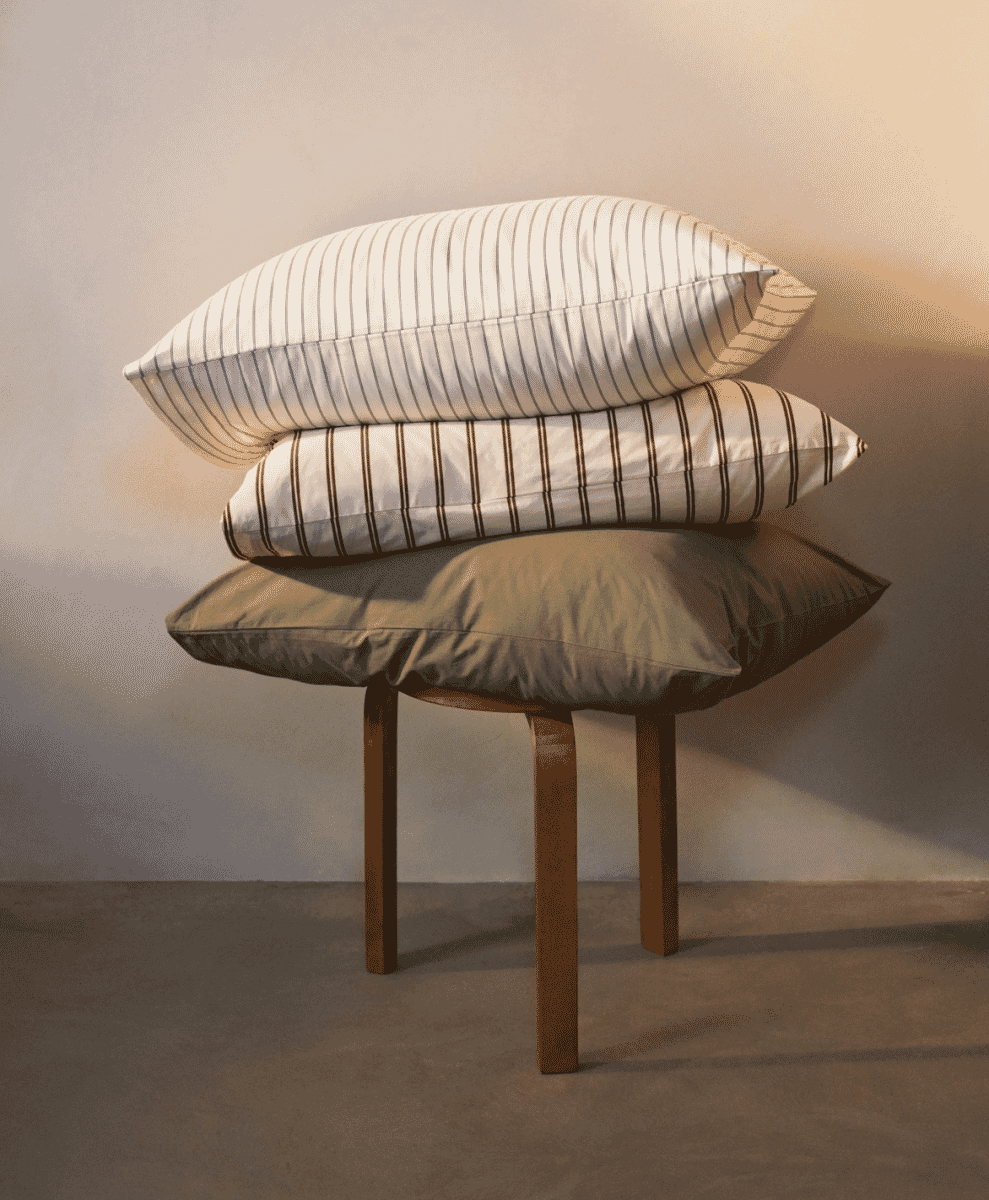 Organic cotton striped loungewear set draped neatly on a minimalist bed.