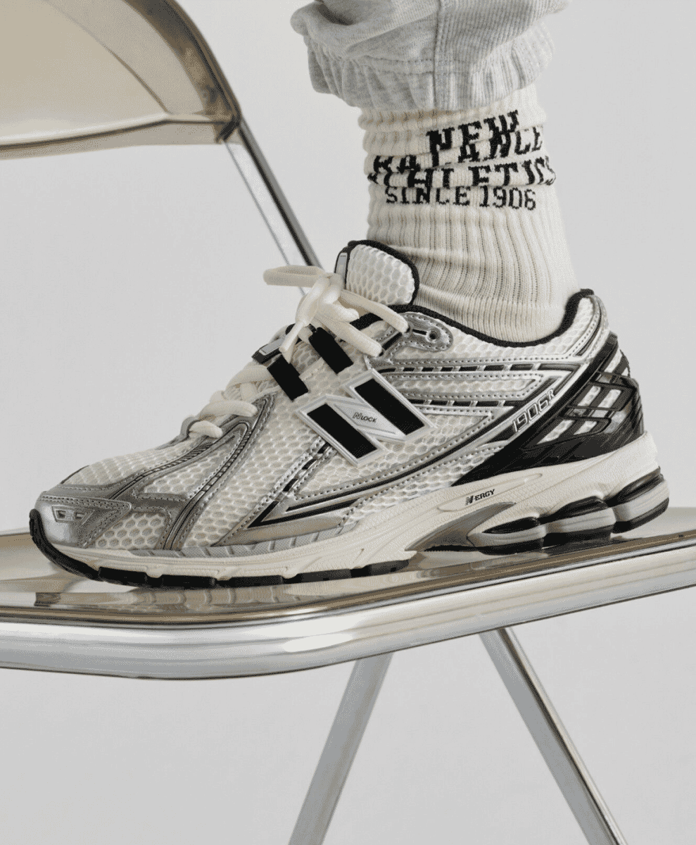 New Balance 1906R sneakers styled with baggy technical trousers in an urban setting.