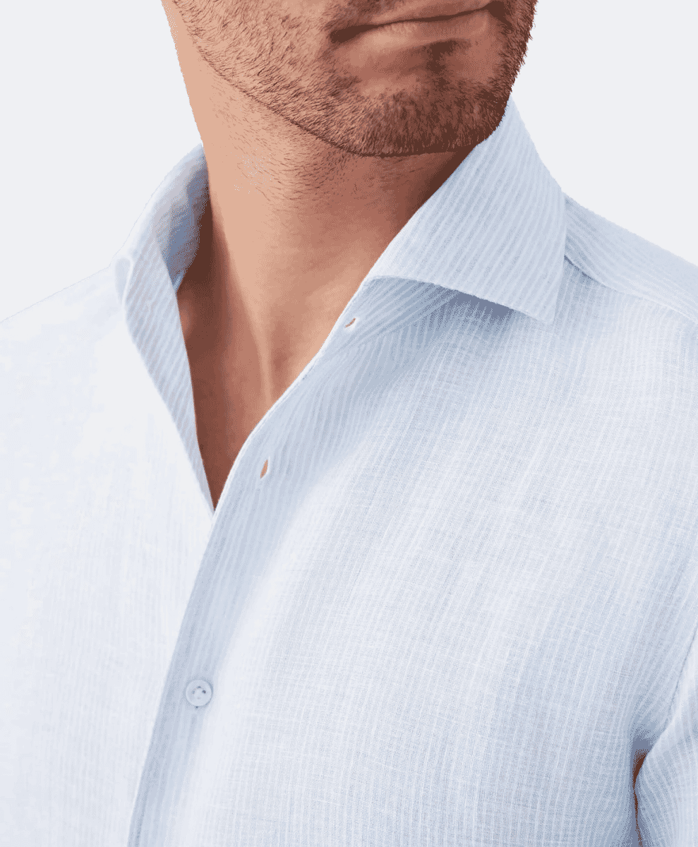Close-up of a man wearing a light blue finely striped dress shirt with a button-down collar.