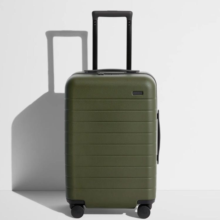 A hard-shell carry-on suitcase in a neutral color.
