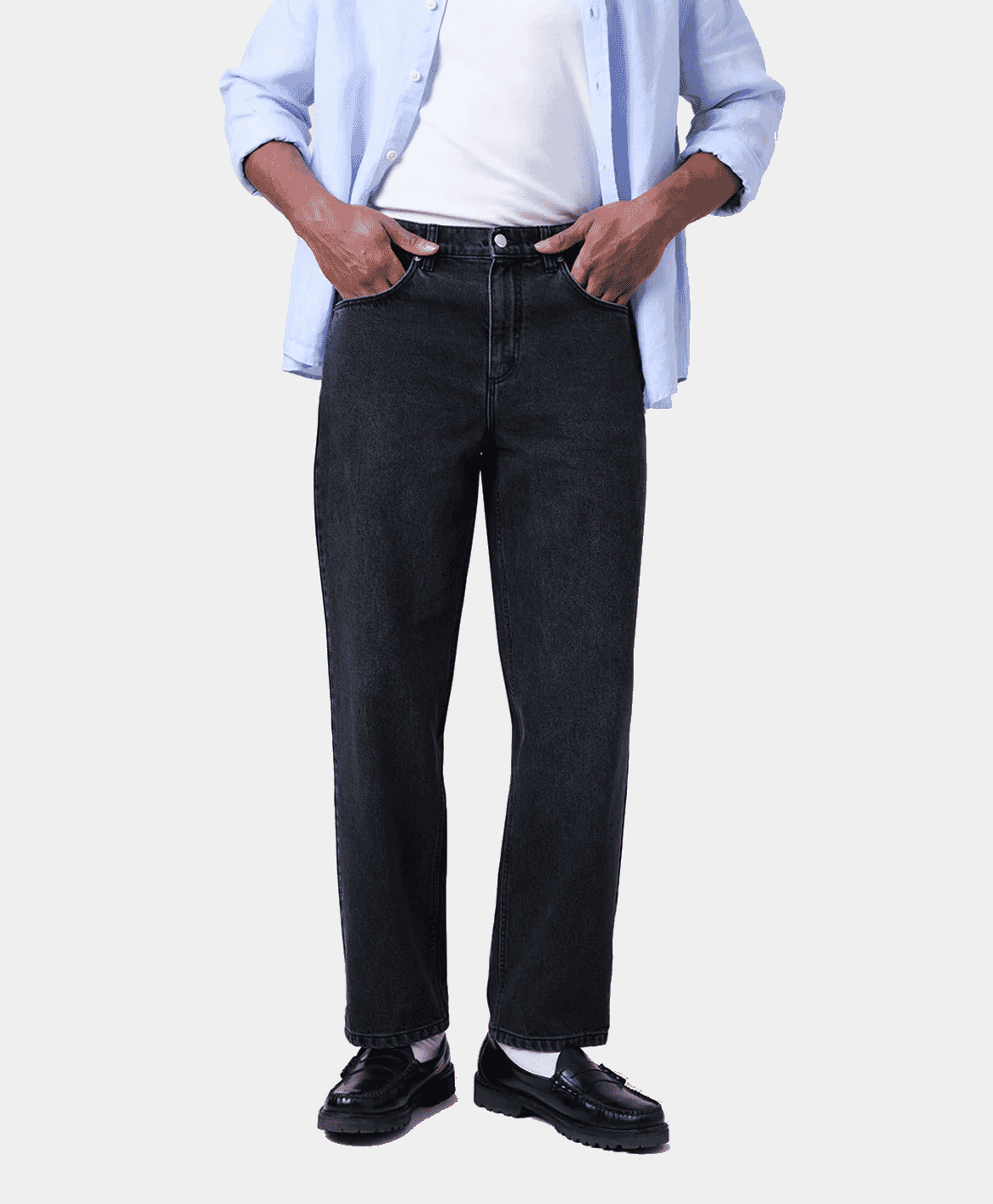 A man wearing washed black straight fit denim jeans paired with black boots.