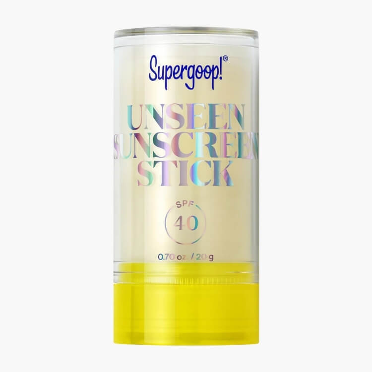 A clear Supergoop! Unseen Sunscreen Stick with a yellow base.