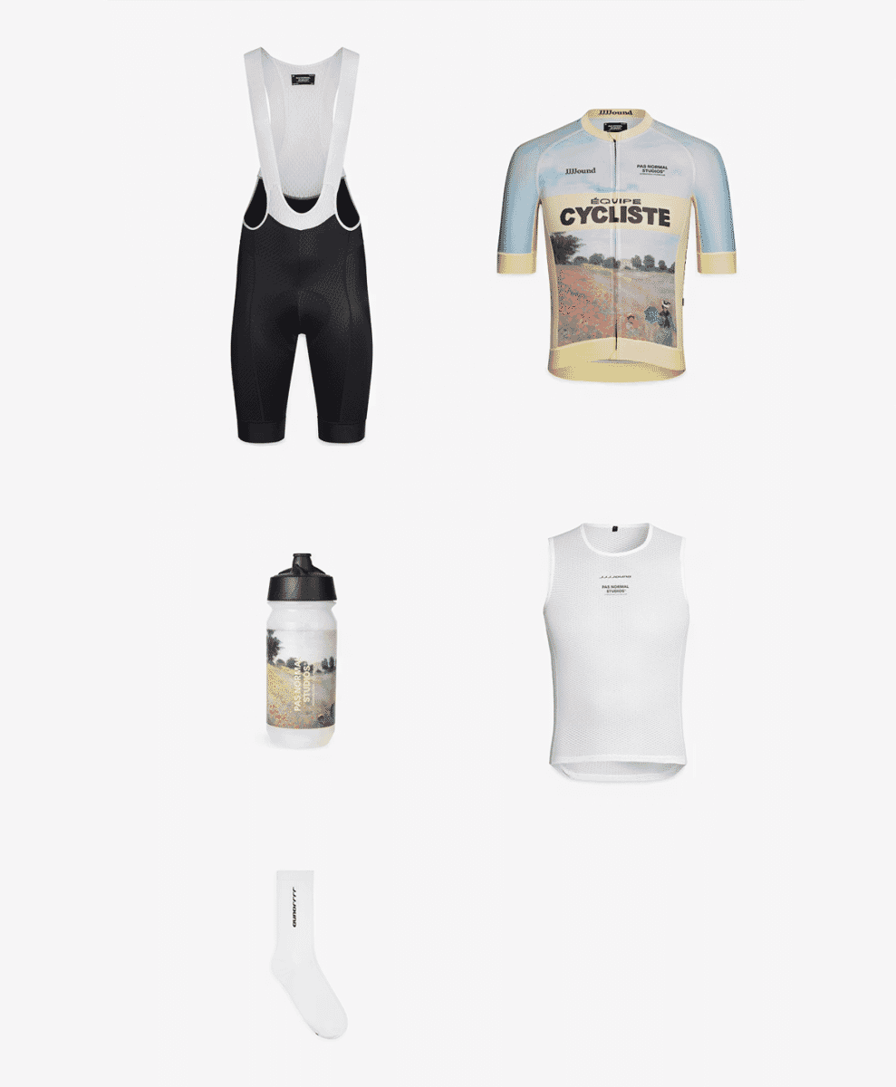 A flat lay of cycling gear including bib shorts, a graphic jersey, a base layer, and a water bottle.