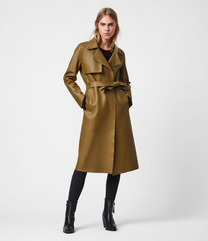 Model wearing an olive green leather trench coat with a belted waist.