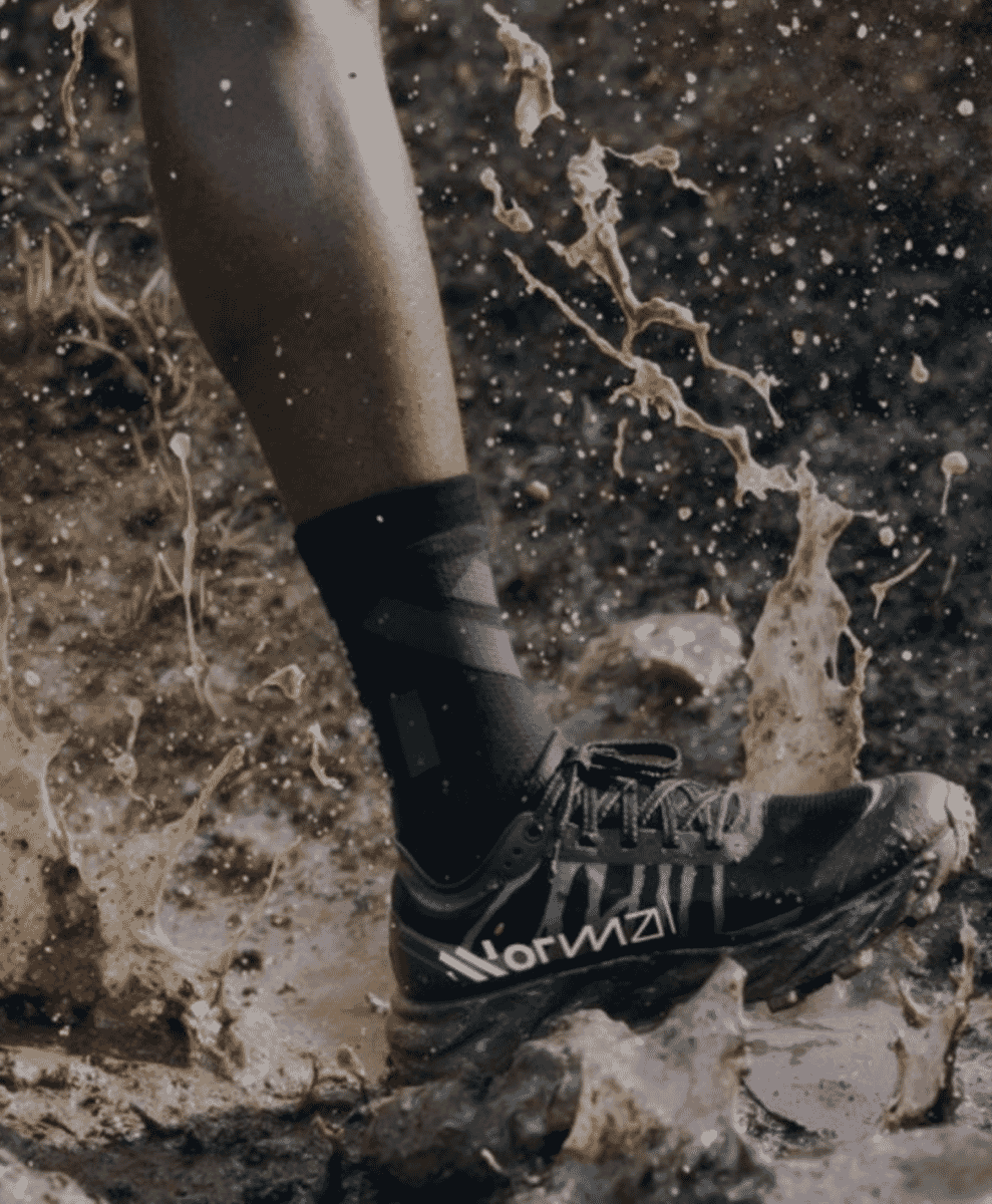 On-foot shot of NNormal sneakers being worn in an outdoor-adjacent setting.