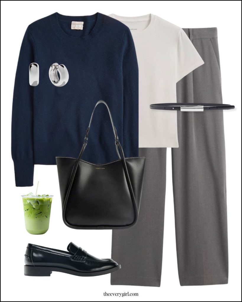 A woman wearing a professional monochromatic navy knit sweater and trousers.