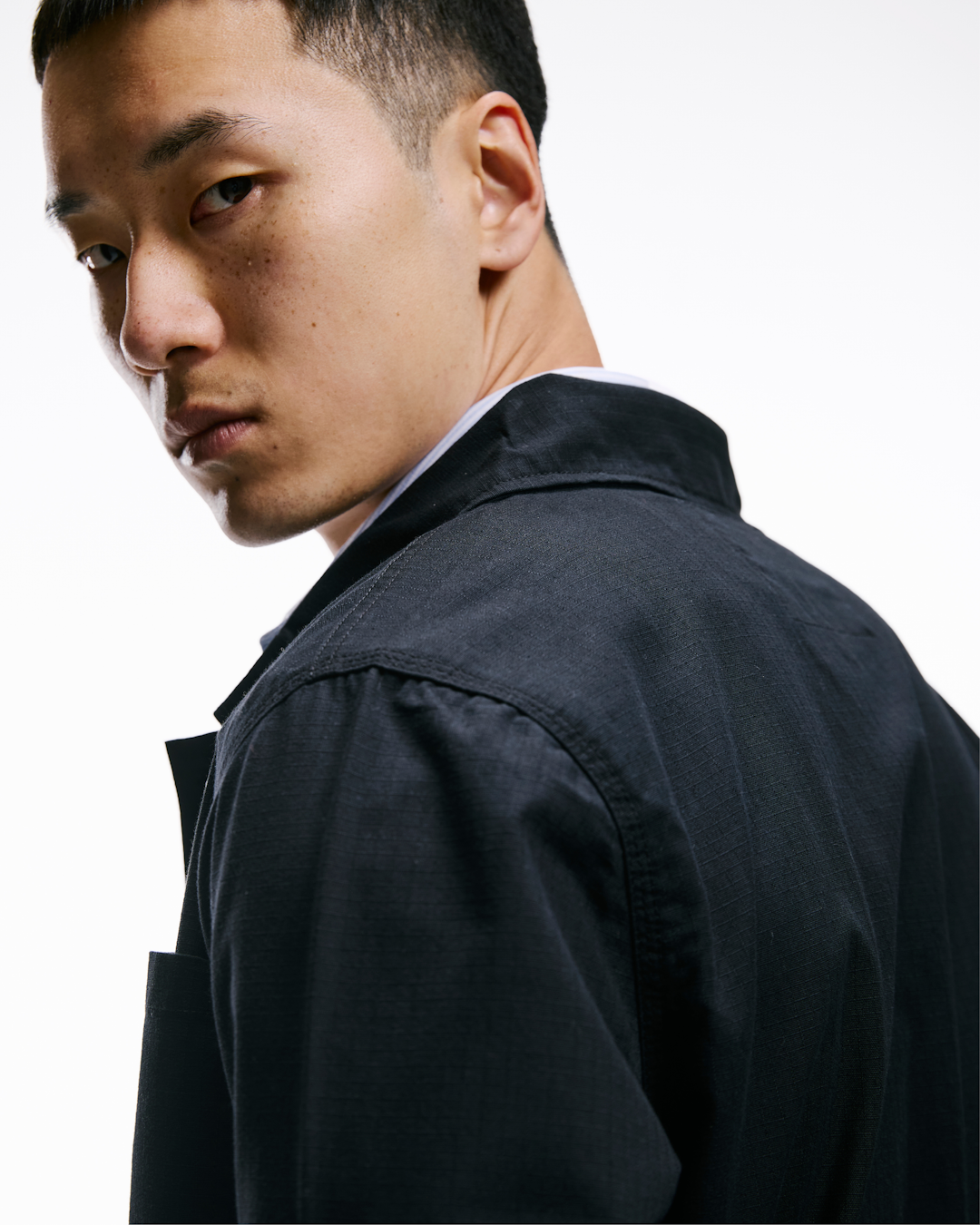 Model in a minimalist workwear outfit featuring a clean-lined ripstop shirt.