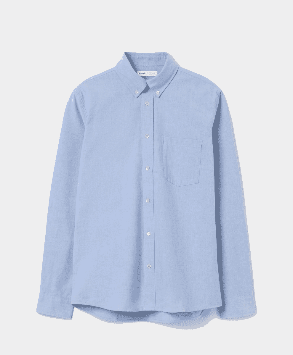 Flat lay of a light blue button-up Oxford shirt with a classic collar.