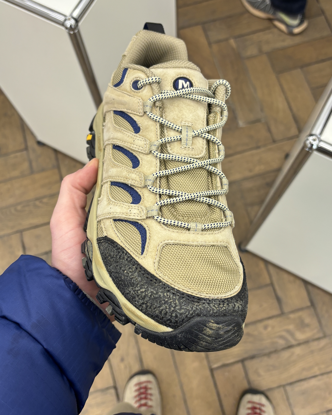 Close-up shot of sandy beige nubuck leather and navy accents with specialized wax processing.