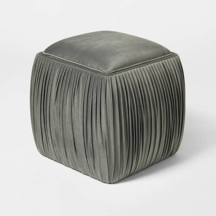 Velvet storage ottoman with ruched fabric detailing on the sides.