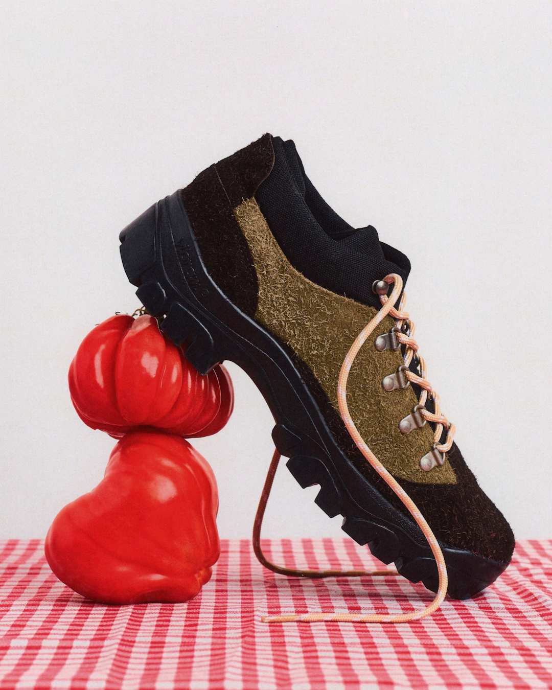 The Big Cheese hiking shoe placed alongside technical trail gear to highlight its hybrid design.