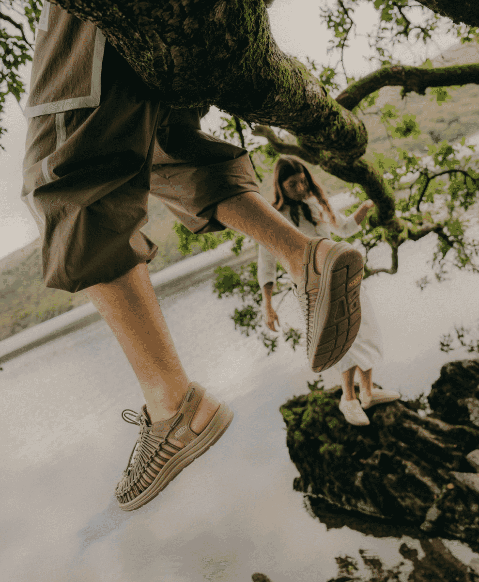 Keen Uneek Sandals placed by a garden path.