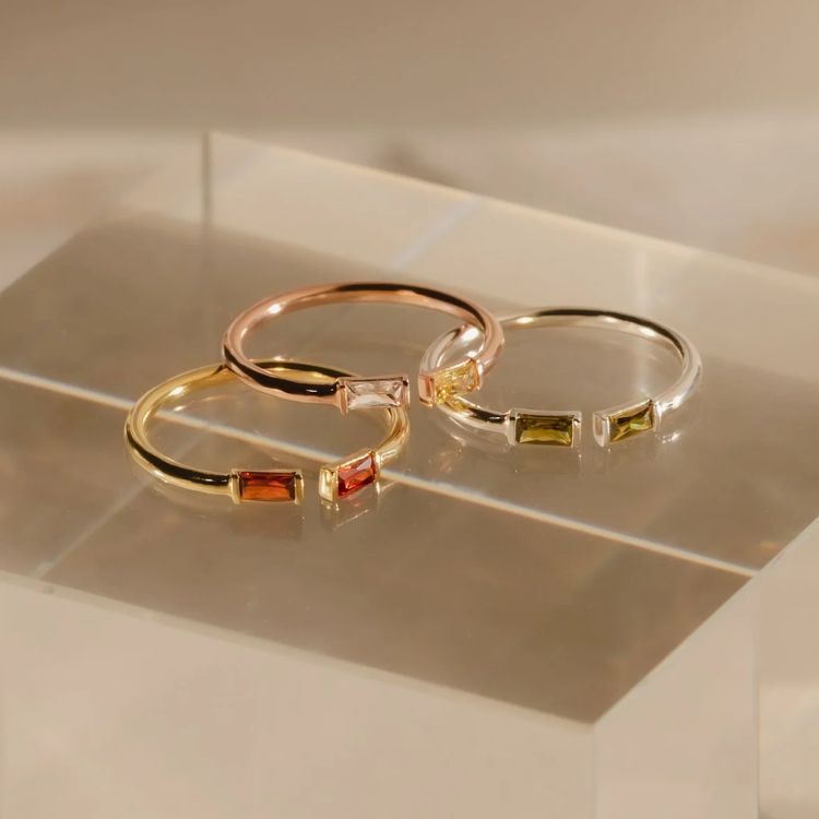 Gold ring with two different baguette-cut birthstones.