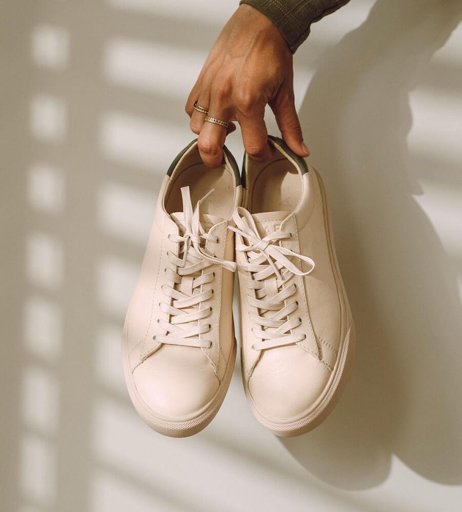 White CLAE minimalist trainers with a classic low-profile tennis silhouette.