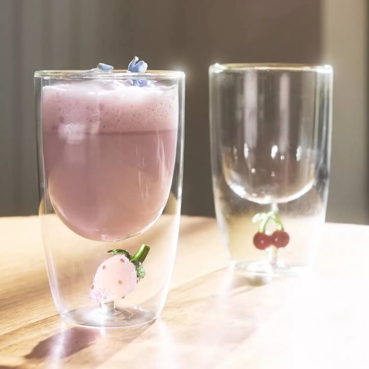 Glass tumbler with printed icons and a glass straw