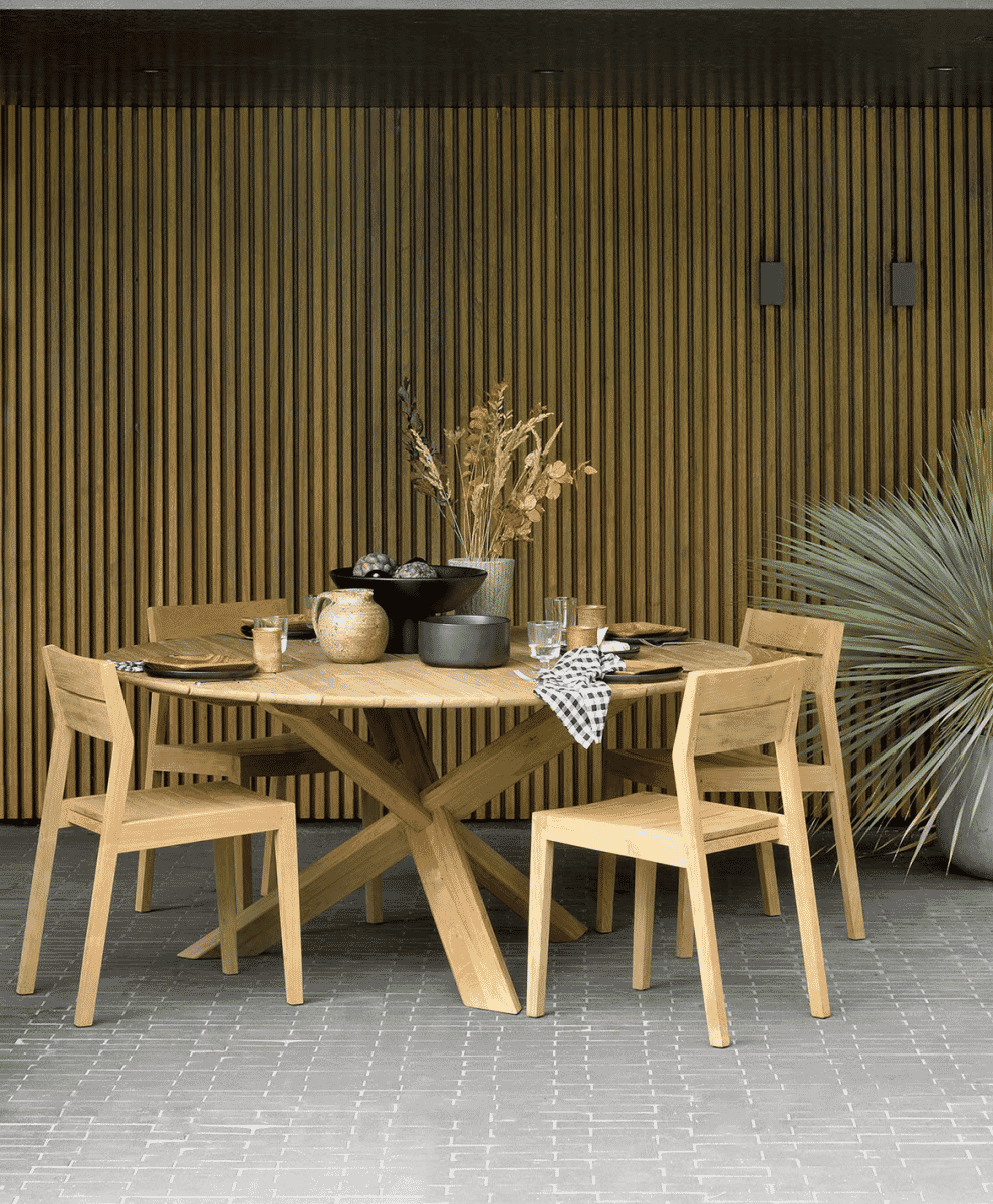 Ethnicraft Circle Outdoor Table in a garden setting.