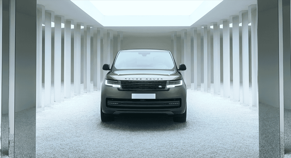 Sleek gray Range Rover SUV in a minimalist white corridor with tall columns.