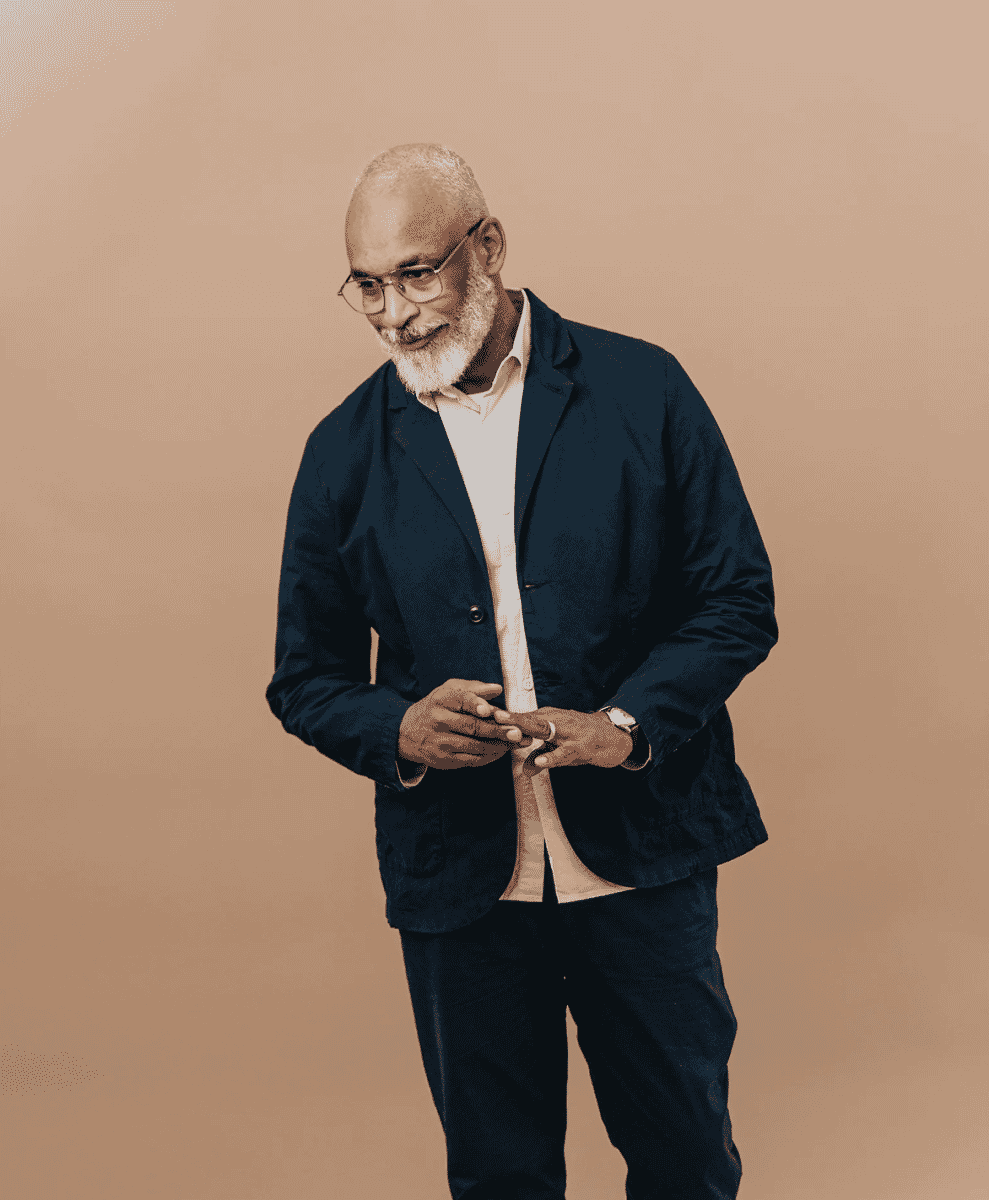 Mature man with a white beard wearing a dark navy casual blazer over a light shirt.