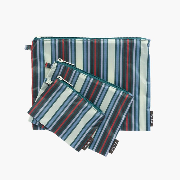 A set of three Calpak zippered pouches with colorful vertical stripes.