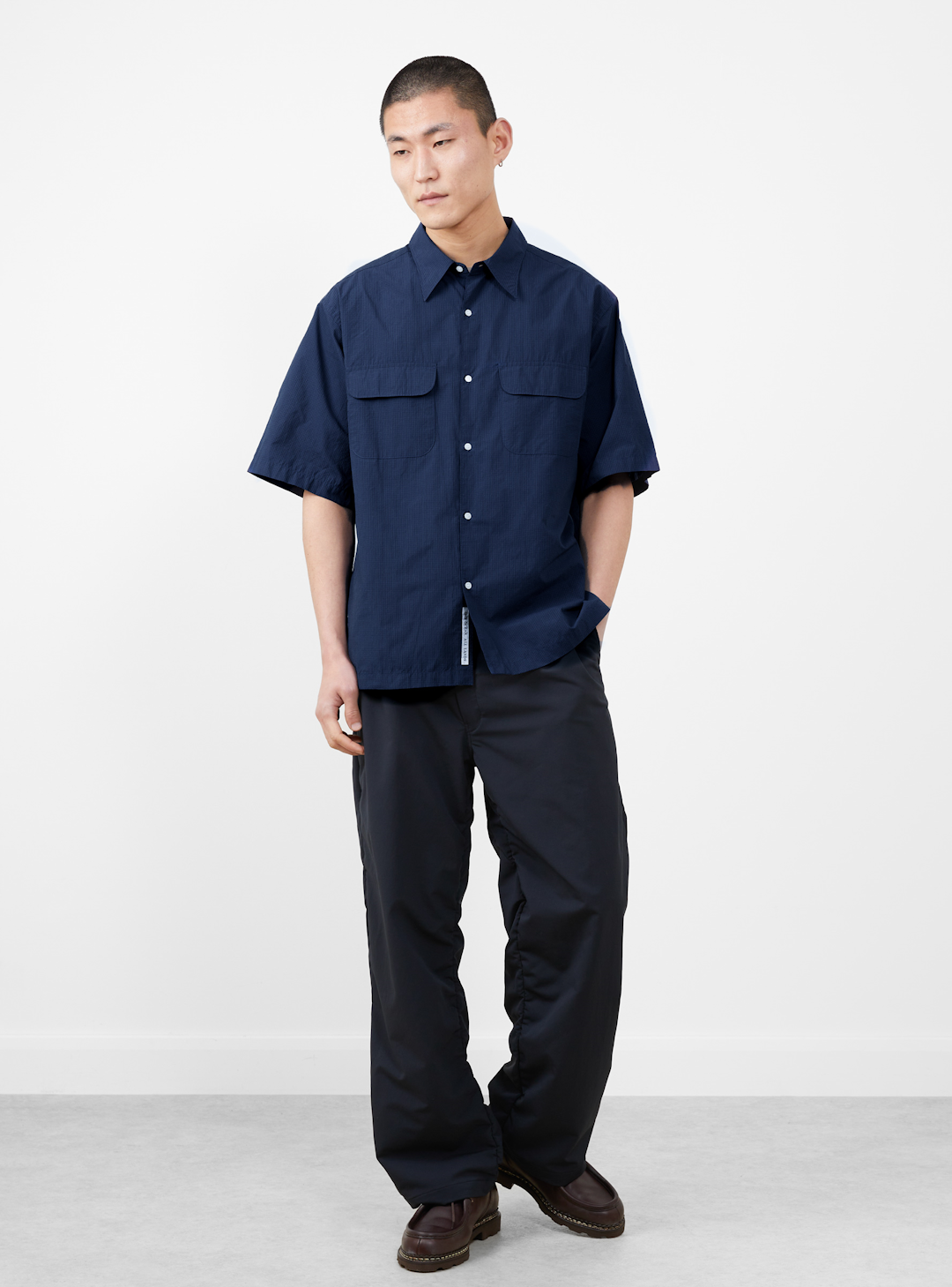 A model in motion wearing lightweight technical layers from Nanamica.