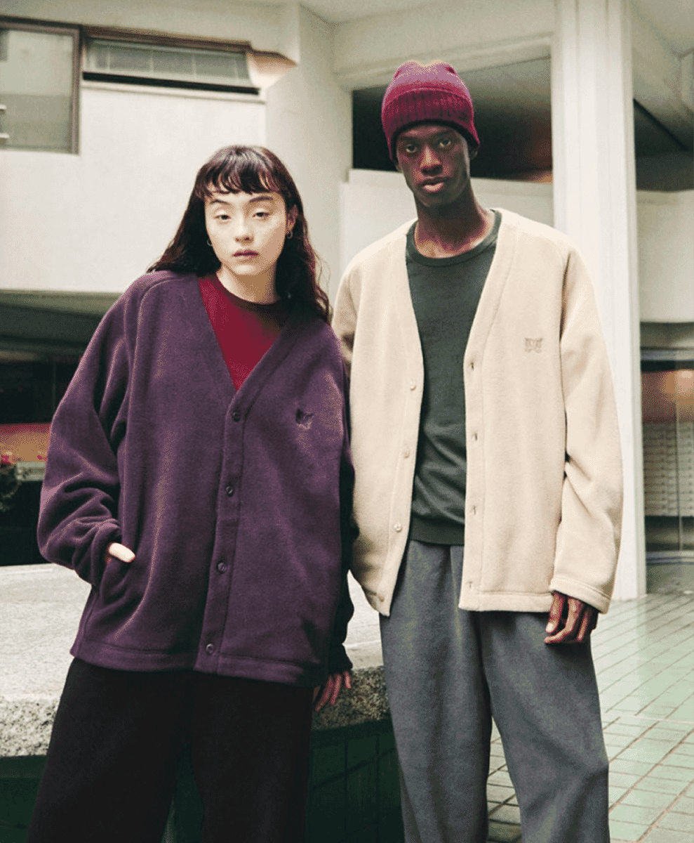 Two models wearing oversized purple and cream fleece cardigans over casual outfits.