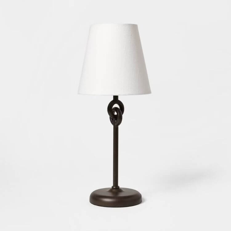 Table lamp featuring a unique metal ring base and a simple white shade.