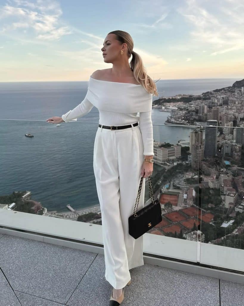 Woman in an off-the-shoulder top overlooking the Monaco coast.