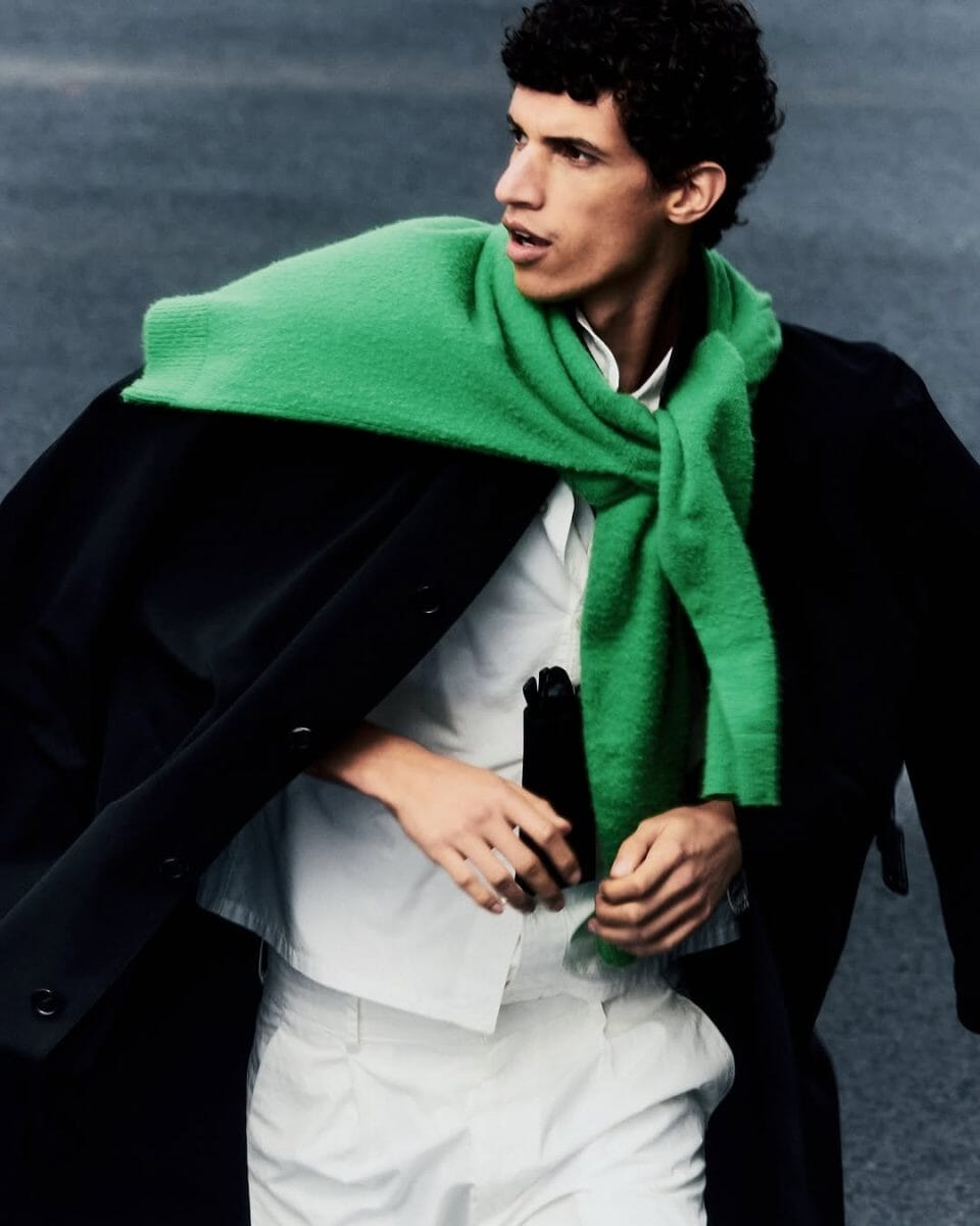 Full-body shot of a model wearing an oversized AURALEE coat in neutral tones.