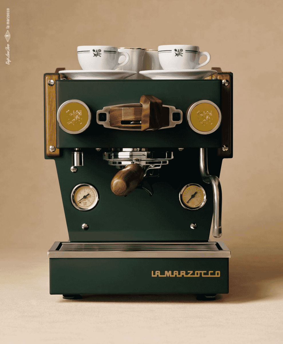 Vintage-style green La Marzocco machine with gold accents and floral ceramic cups.