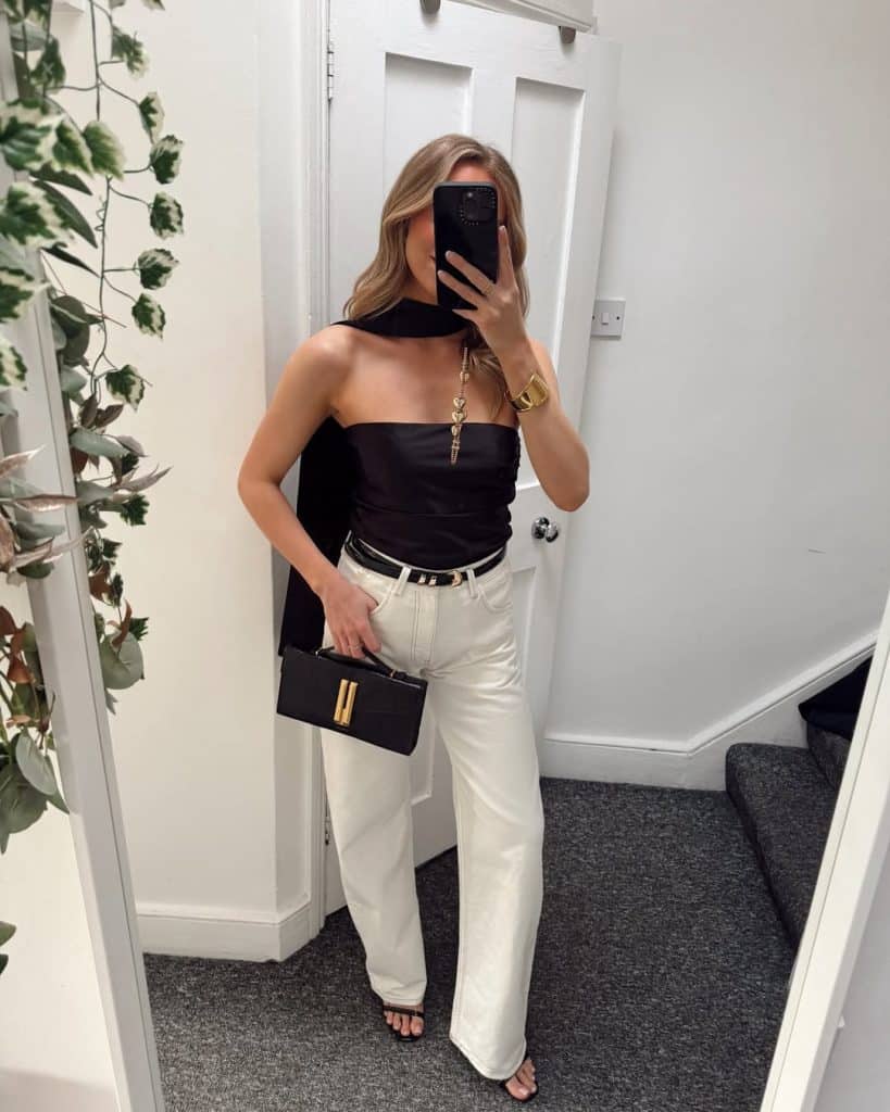 Selfie of a black satin strapless top paired with white wide-leg trousers.