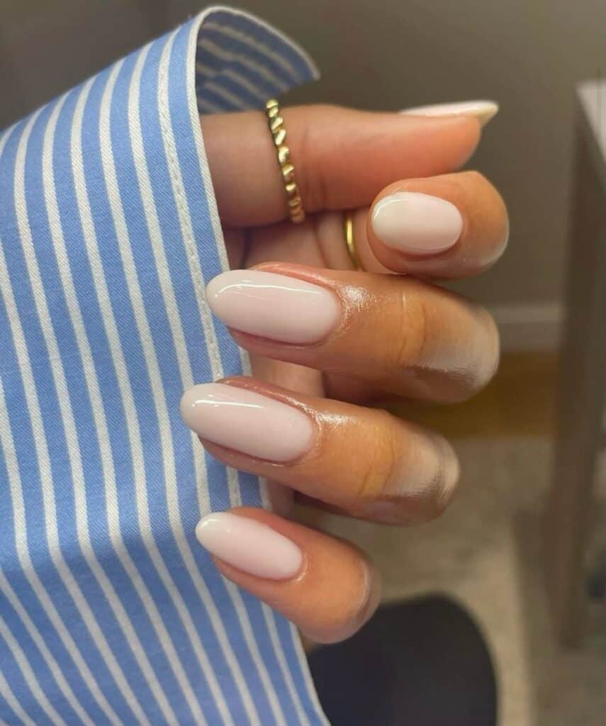 Short squoval nails styled with a classic neutral polish.