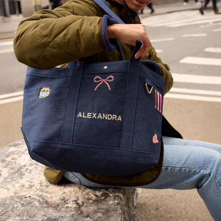 A structured tote bag featuring custom icon patches.