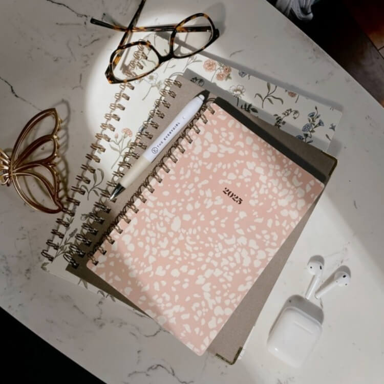 Stack of floral and patterned planners and notebooks