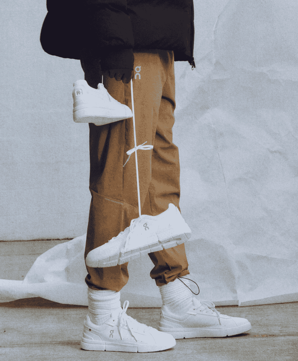 Close-up detail of smooth white calfskin leather and fine stitching on a premium sneaker.
