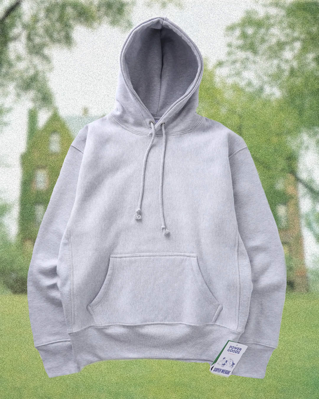 A grey marl hoodie layered underneath a tailored camel wool topcoat for a minimalist aesthetic.