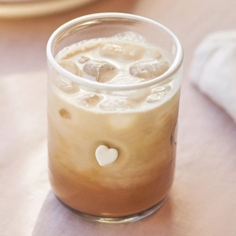 Glass tumbler decorated with small red heart icons.
