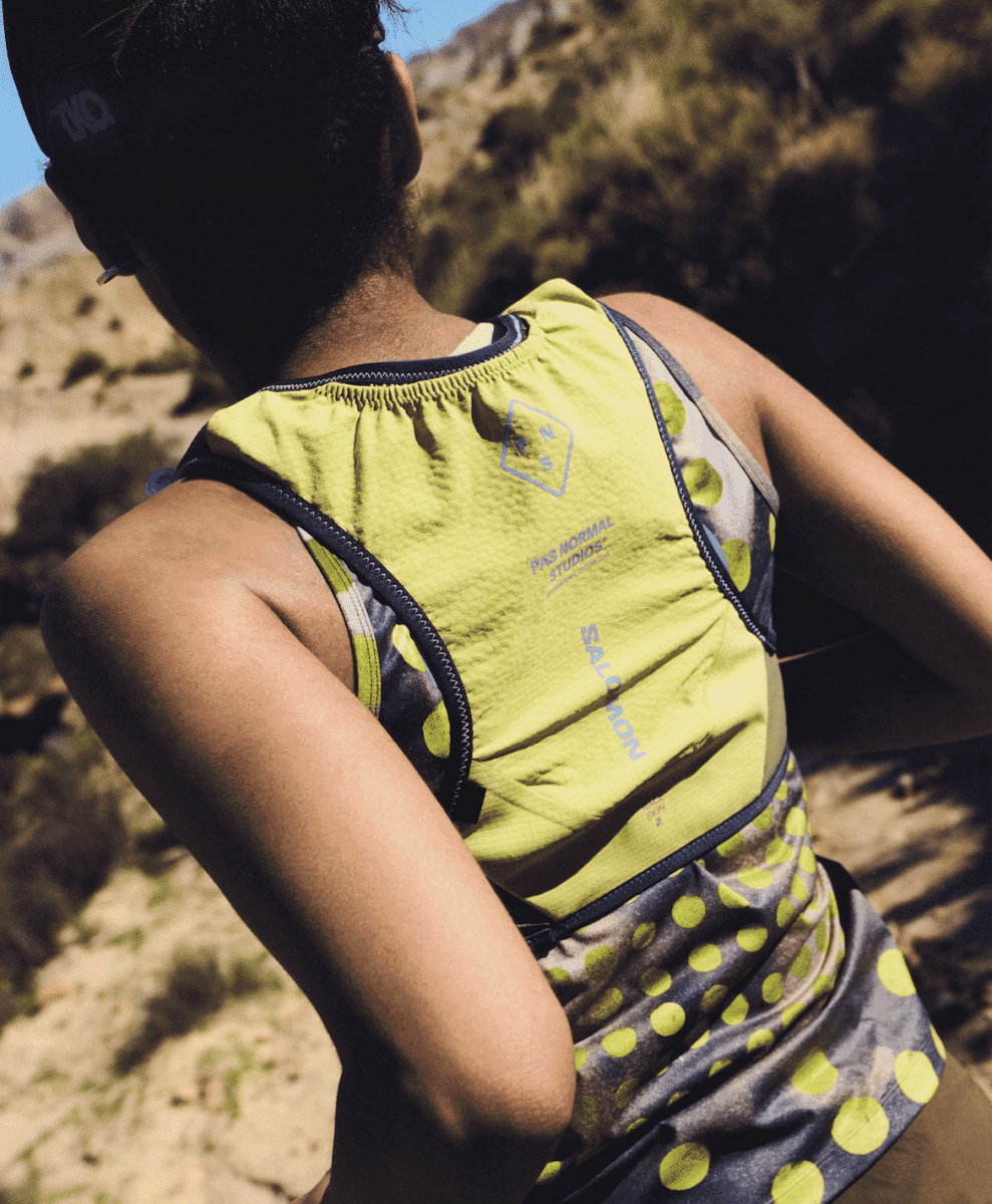 Full body action shot of the runner in the complete Salomon x PNS capsule on a gravel road.