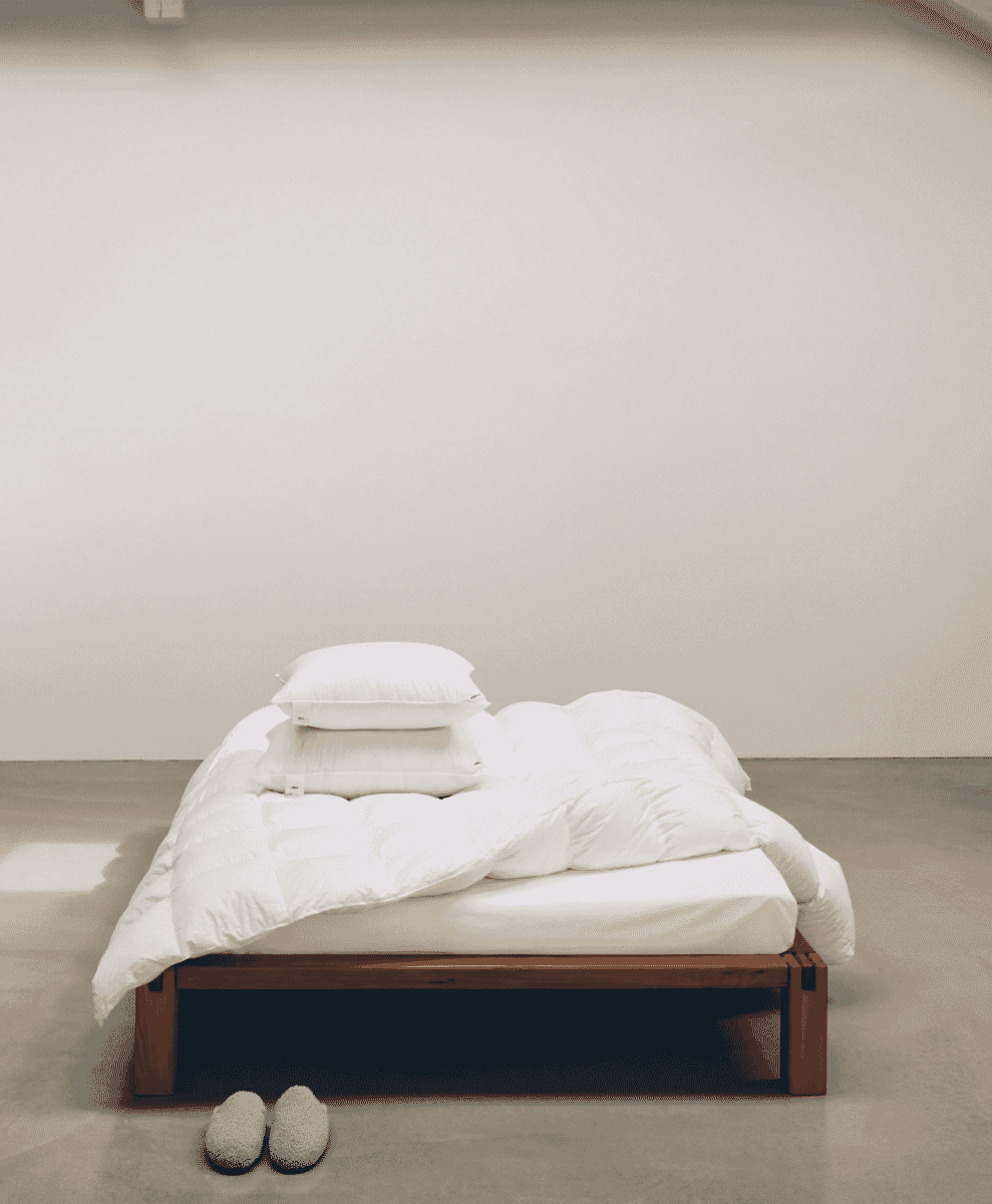 Folded organic cotton towels in various muted shades of grey and blue.