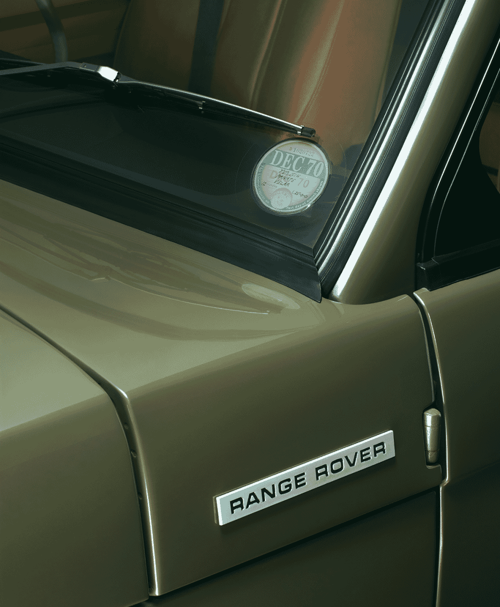 Close-up of a vintage olive-green Range Rover with 1970s registration sticker.