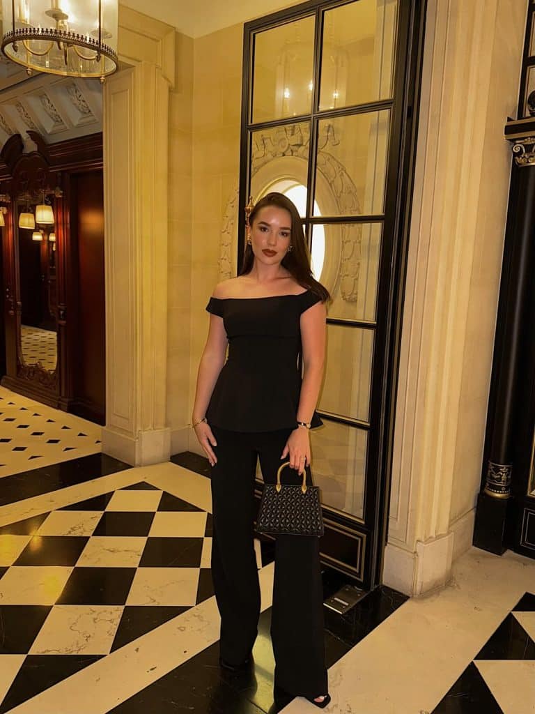 Woman in a black off-the-shoulder peplum top and wide-leg trousers.