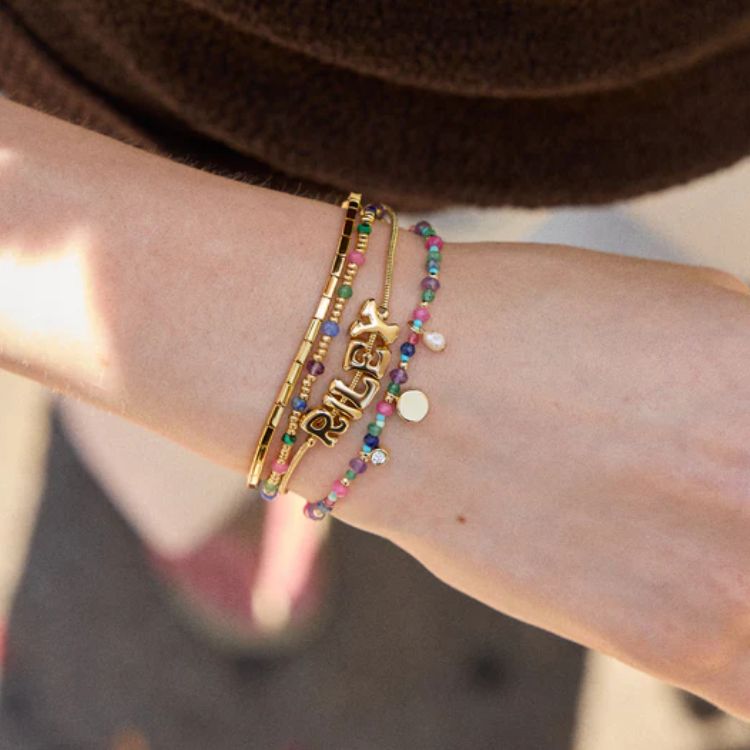 A custom layered bracelet featuring multiple strands and personalized elements.