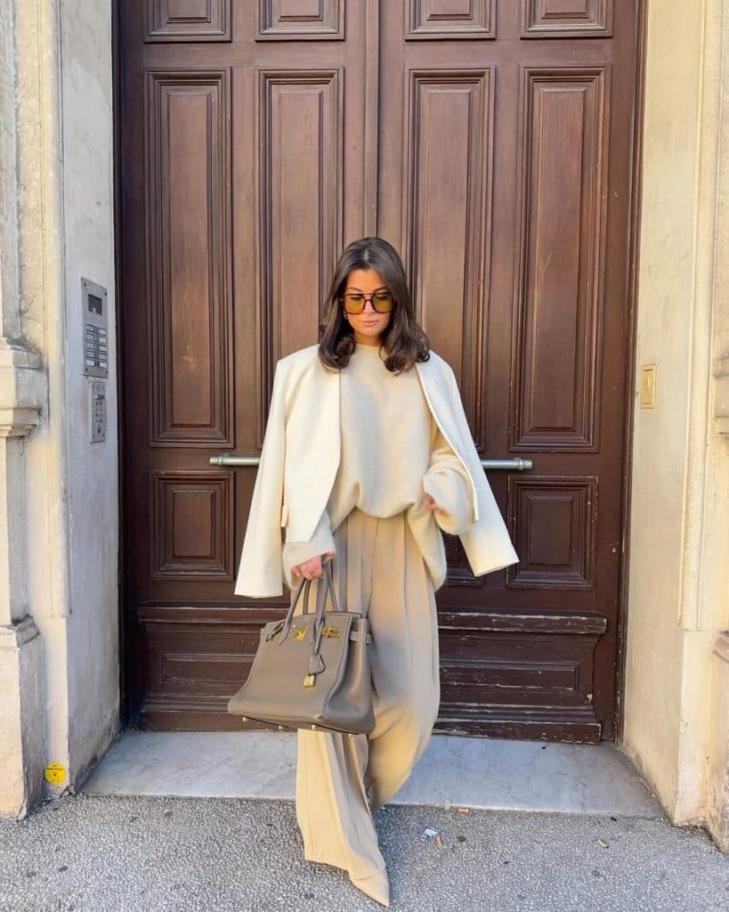 Woman in a full beige ensemble including an oversized blazer and wide-leg trousers.