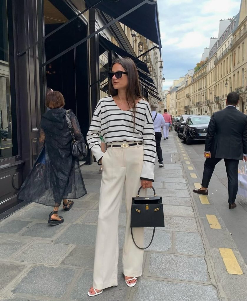 A woman in a neutral blazer and matching wide leg pants.