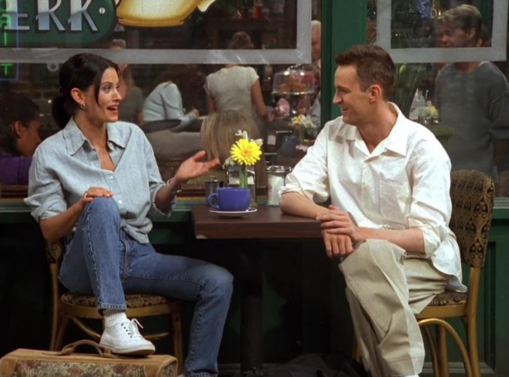 Monica Geller in a dark denim button-down shirt.