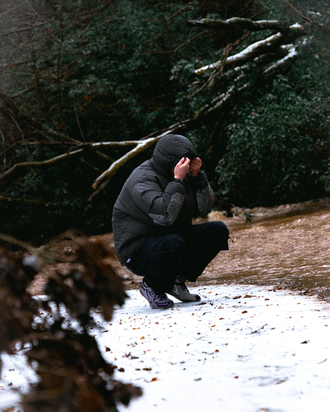 Full-body shot of a model wearing a JUGEM parka with technical trousers and boots.