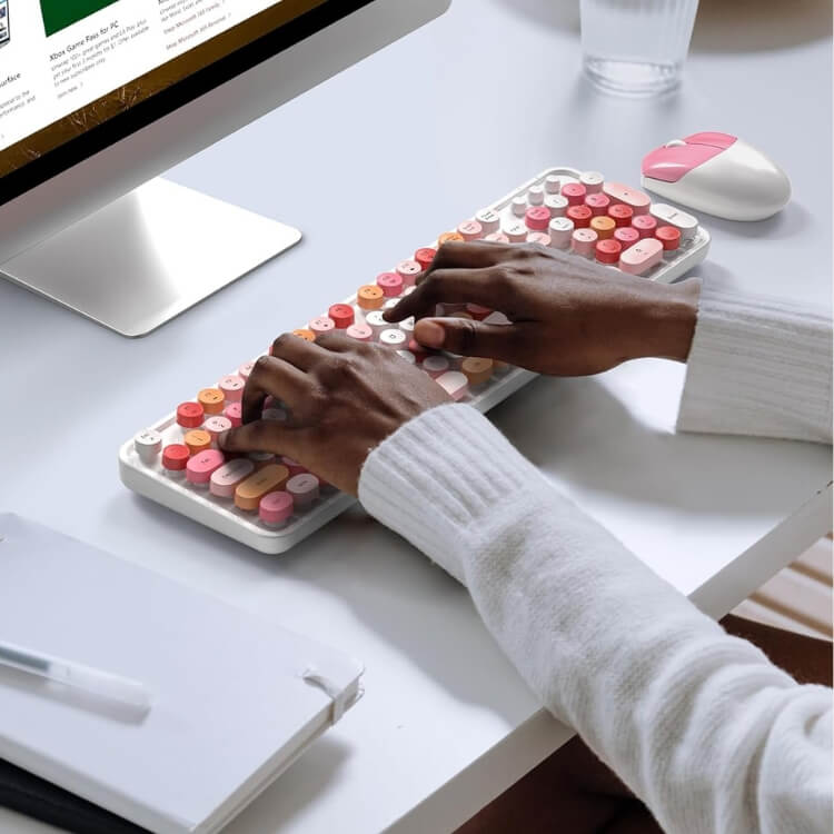 Minimalist white wireless keyboard on a wooden desk