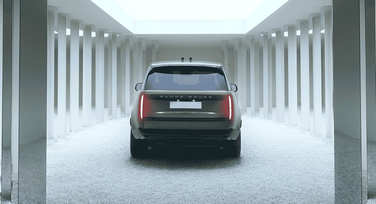 Rear view of a modern Range Rover in a white, minimalist architectural corridor.